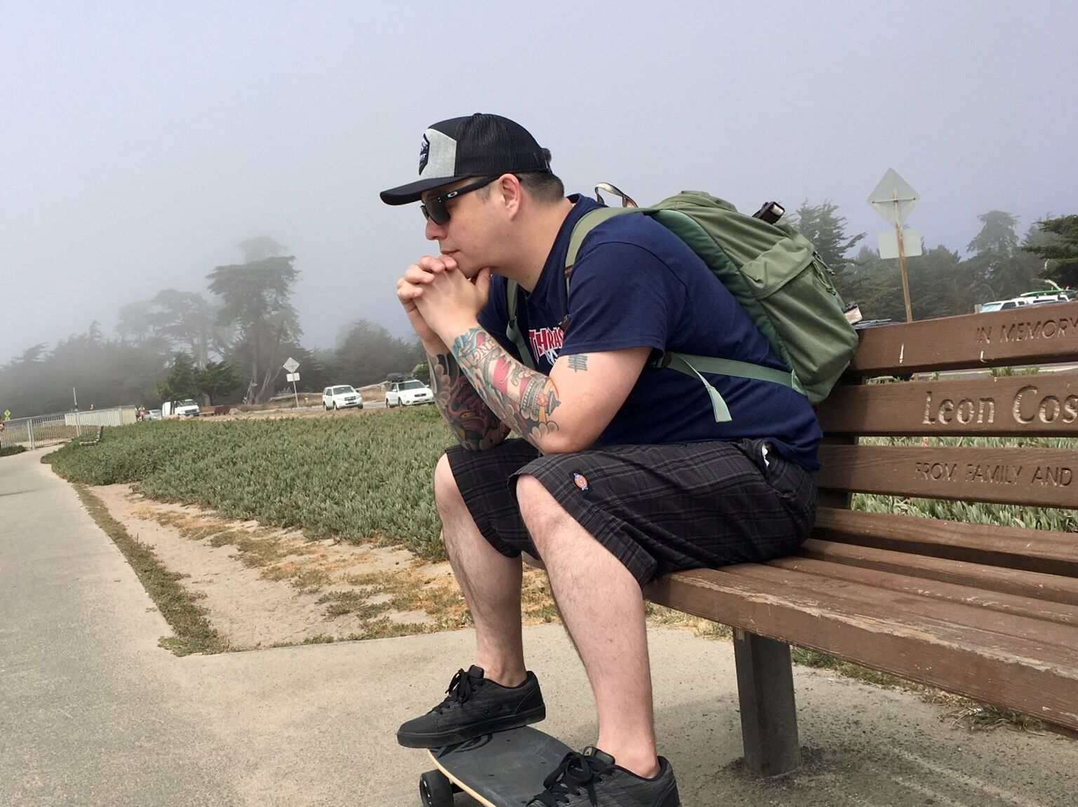 Christopher sitting on a bench along the coast in Santa Cruz, California